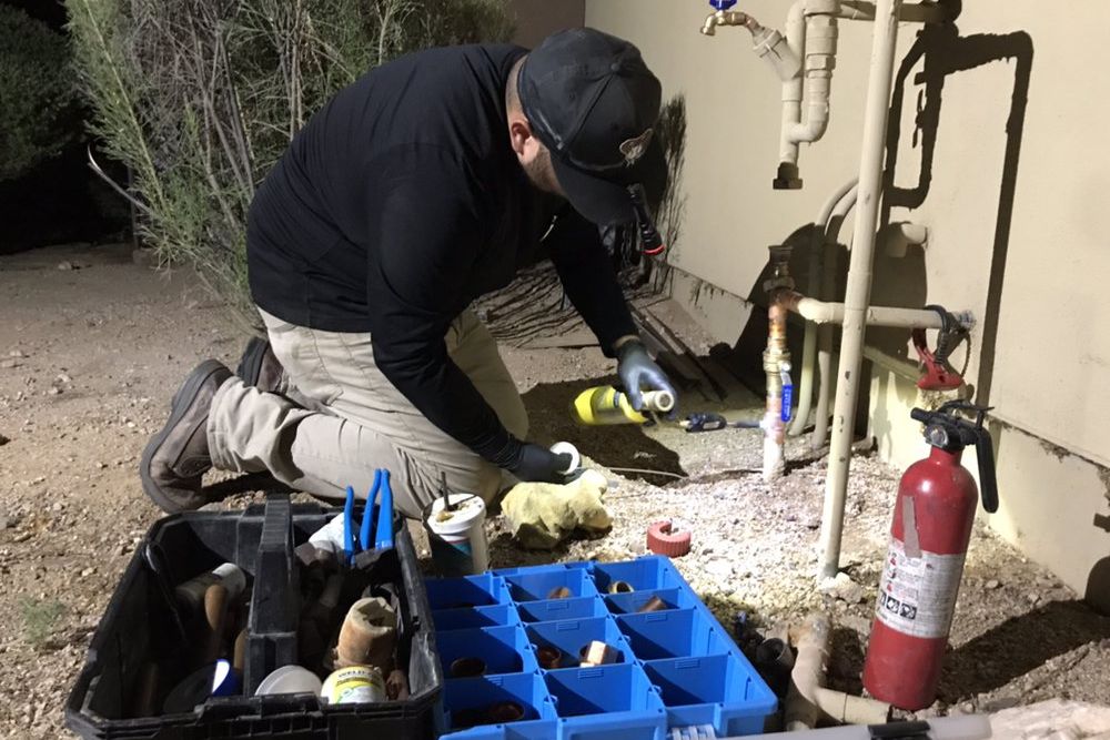 Newtech plumber replacing a ball valve on a gas line beside a house